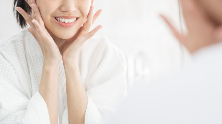 フェイスラインに手を添える女性