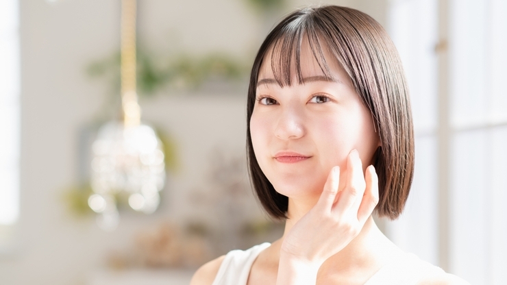 フェイスラインに手を添える女性
