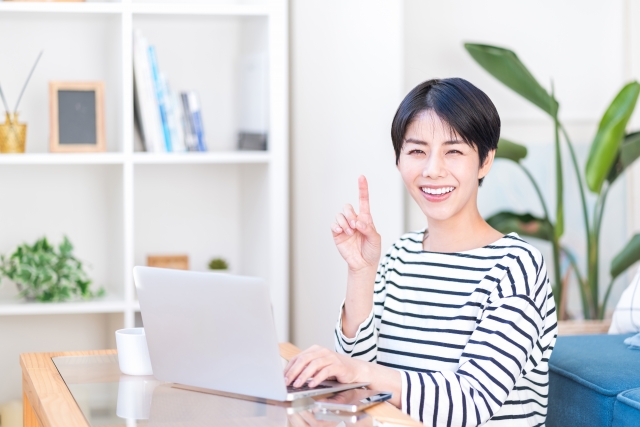 笑顔で人差し指を立てる女性